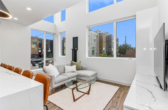 living area featuring recessed lighting, baseboards, and light wood-style flooring