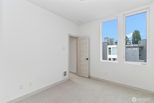 empty room with visible vents, baseboards, and carpet