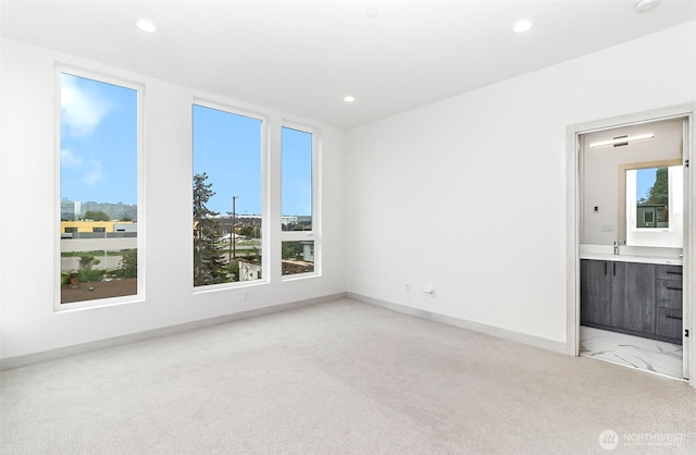 spare room featuring recessed lighting, light carpet, and a healthy amount of sunlight