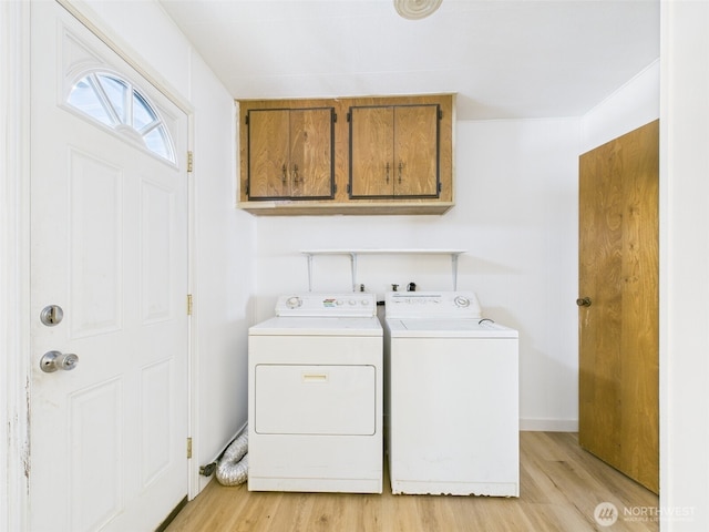 laundry area featuring light wood-type flooring, cabinet space, and washing machine and dryer