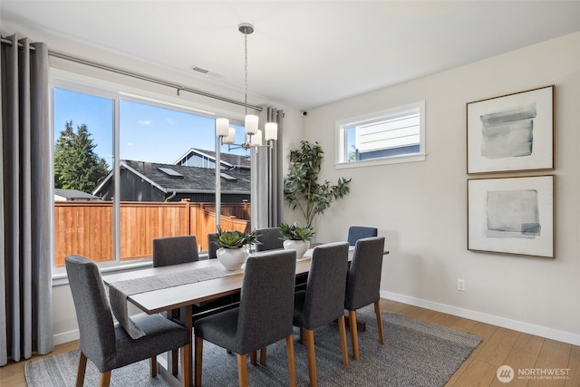 dining room featuring baseboards, an inviting chandelier, and wood finished floors