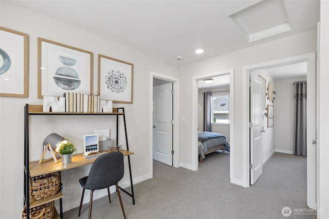 carpeted home office featuring attic access and baseboards