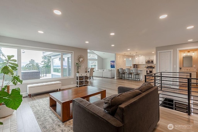 living area featuring recessed lighting, light wood-type flooring, and baseboards