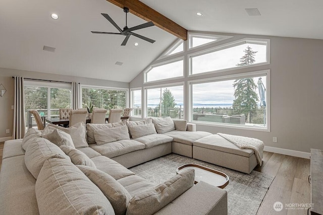 living room featuring a ceiling fan, baseboards, high vaulted ceiling, beamed ceiling, and light wood-type flooring