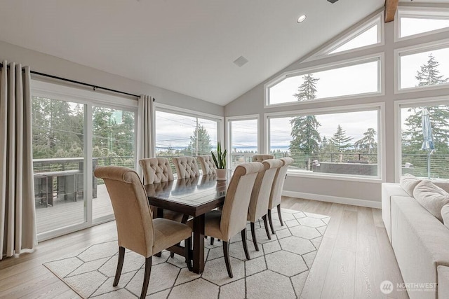 dining room with plenty of natural light, visible vents, light wood-type flooring, and high vaulted ceiling