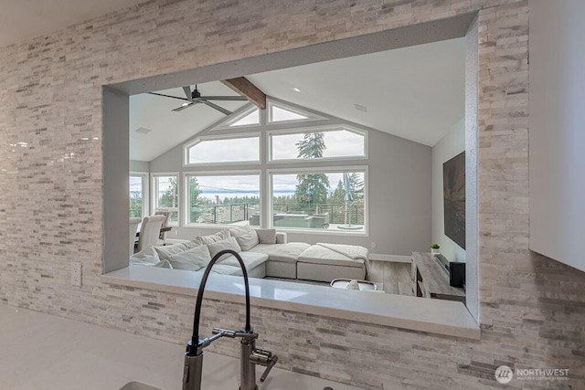 unfurnished living room featuring beam ceiling, high vaulted ceiling, ceiling fan, and wood finished floors