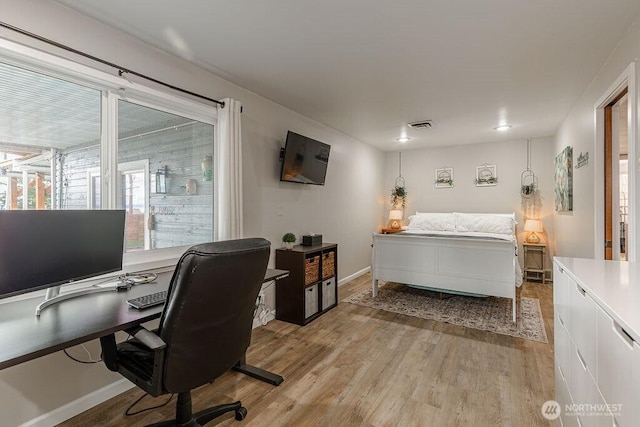 bedroom with light wood-style flooring and baseboards