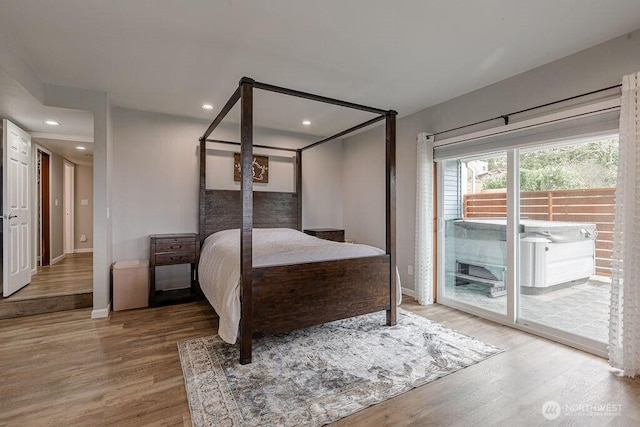 bedroom featuring access to exterior, recessed lighting, wood finished floors, and baseboards