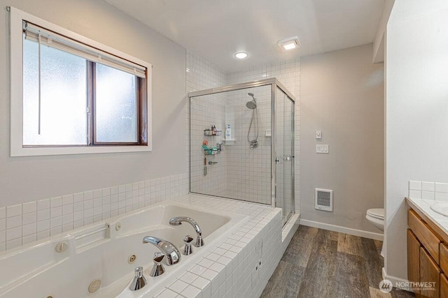 bathroom featuring visible vents, toilet, a stall shower, vanity, and a whirlpool tub