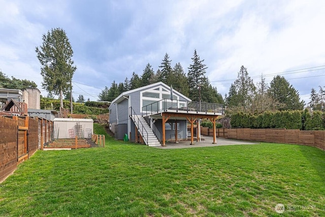 view of yard featuring stairs, a patio area, a deck, and a fenced backyard