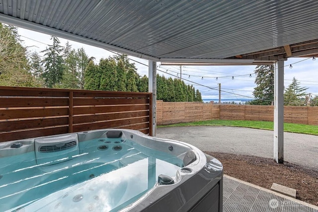 view of patio featuring fence and a hot tub