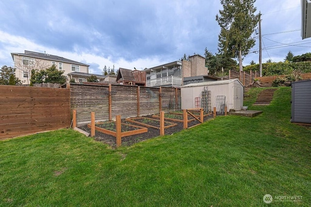 view of yard with an outbuilding, a vegetable garden, and a fenced backyard