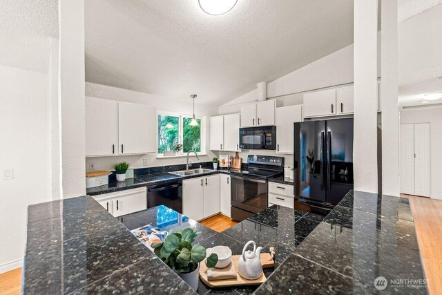 kitchen with black appliances, light wood-type flooring, lofted ceiling, and a sink