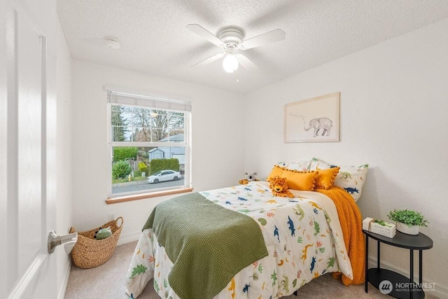 bedroom with a ceiling fan, carpet floors, and a textured ceiling