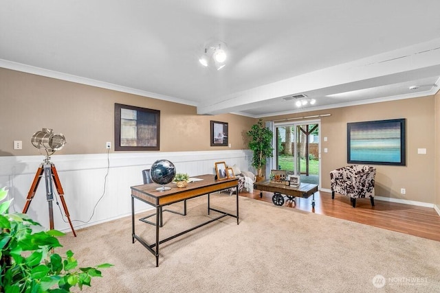 home office with visible vents, crown molding, a wainscoted wall, carpet flooring, and wood finished floors