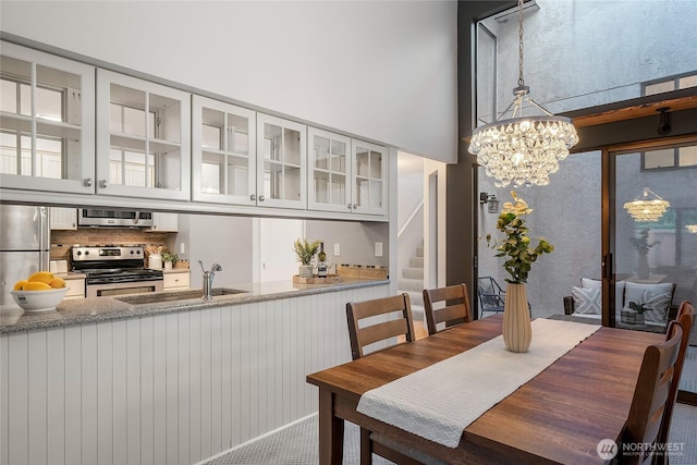 dining space featuring stairway and an inviting chandelier