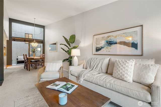 living room featuring an inviting chandelier and carpet floors