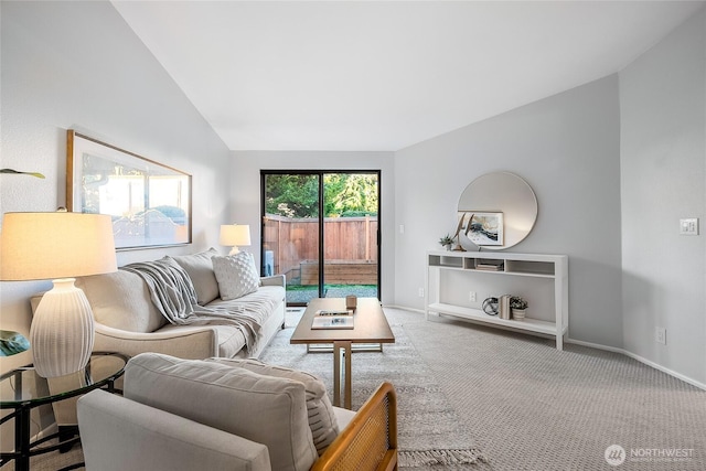 living area featuring baseboards, carpet, and vaulted ceiling