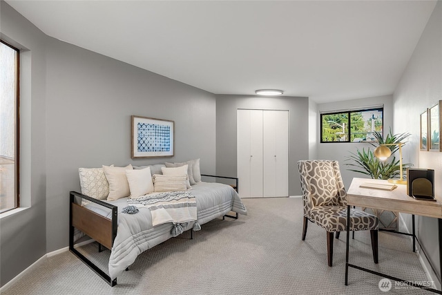 carpeted bedroom featuring a closet and baseboards