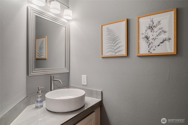 bathroom featuring vanity and a textured wall