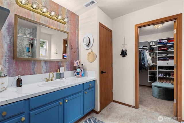 full bathroom featuring visible vents, a shower stall, baseboards, a spacious closet, and vanity