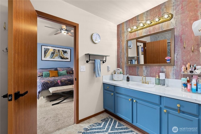 bathroom featuring ceiling fan, baseboards, ensuite bath, and vanity