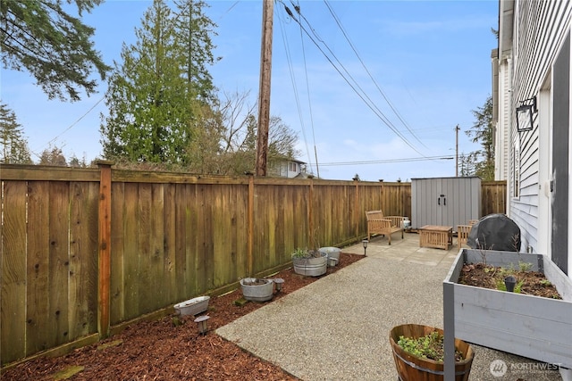 view of patio featuring an outbuilding, area for grilling, a fenced backyard, and a shed