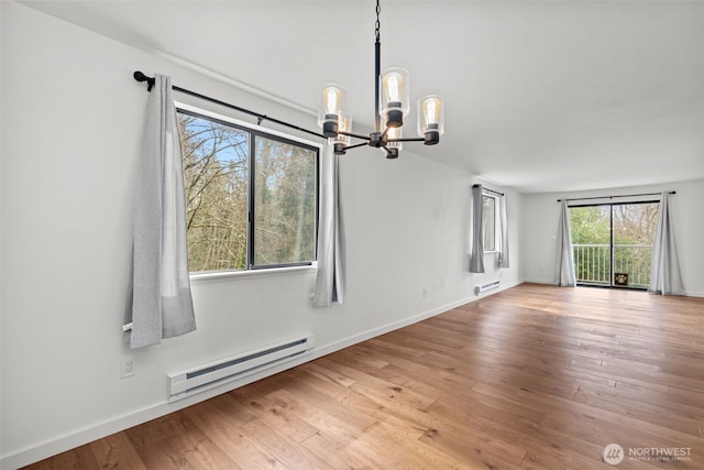 unfurnished dining area featuring a chandelier, baseboard heating, baseboards, and wood finished floors