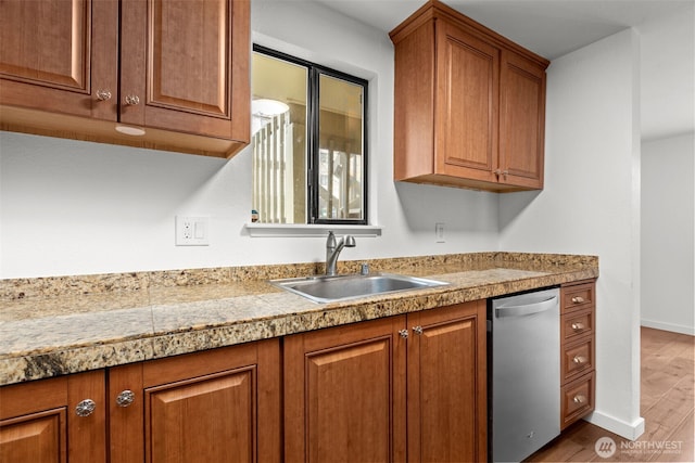 kitchen with tile counters, a sink, brown cabinetry, and stainless steel dishwasher