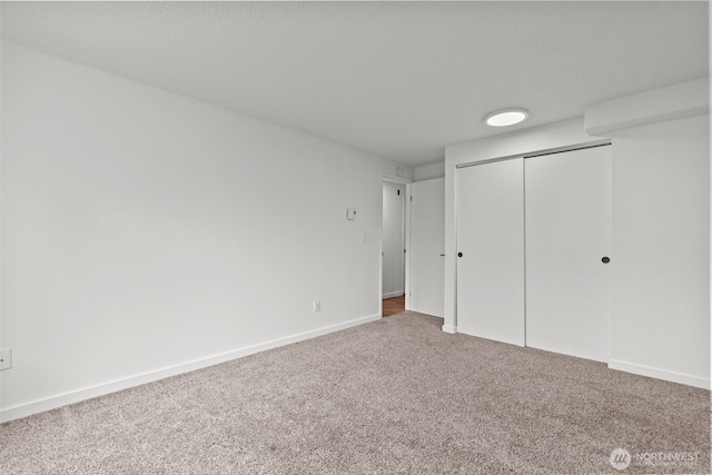 unfurnished bedroom featuring a closet, baseboards, and carpet floors