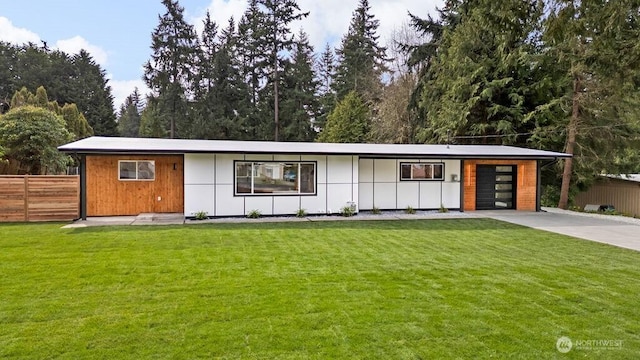 view of front of property featuring a front lawn, an attached garage, fence, and driveway