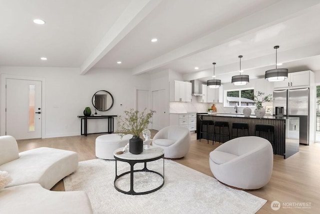 living area with beamed ceiling, recessed lighting, light wood-style flooring, and baseboards