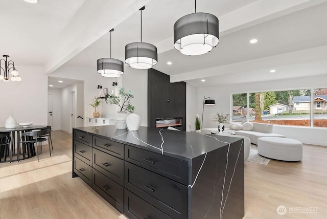 kitchen featuring recessed lighting, beamed ceiling, light wood-style floors, and open floor plan