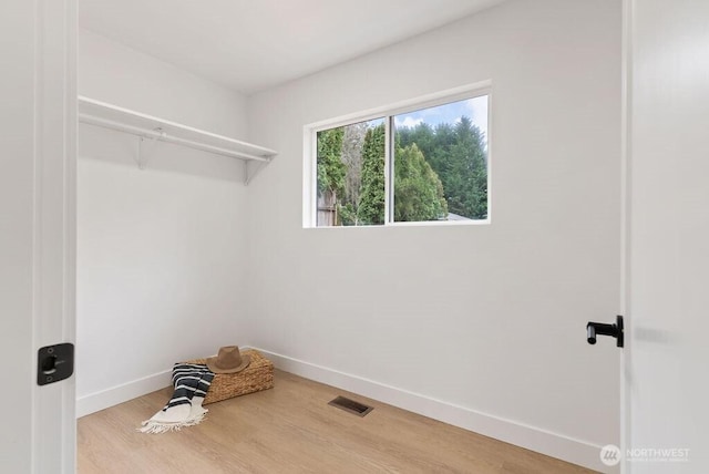 spacious closet featuring wood finished floors and visible vents