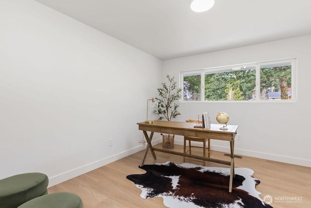 office area featuring light wood finished floors, visible vents, and baseboards