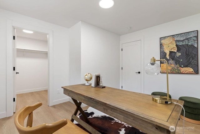 office space with baseboards and light wood-style floors