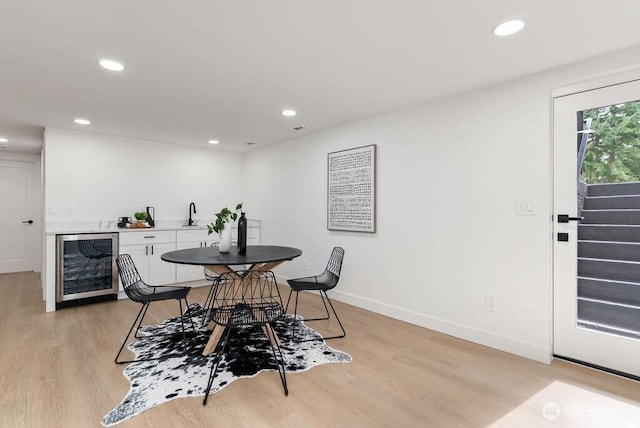 dining area featuring recessed lighting, stairway, light wood-style floors, and beverage cooler