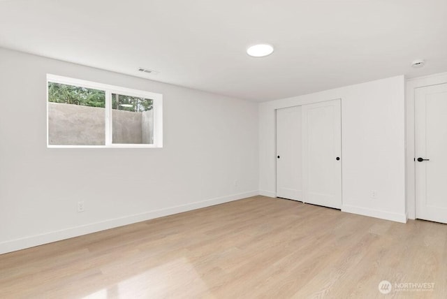 unfurnished bedroom featuring visible vents, baseboards, and light wood finished floors