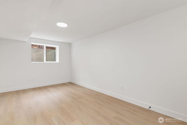 empty room featuring baseboards and light wood-style flooring