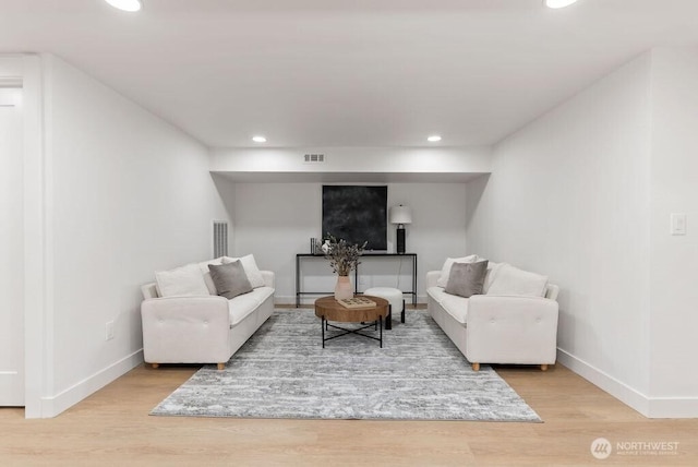 living room featuring recessed lighting, baseboards, and wood finished floors