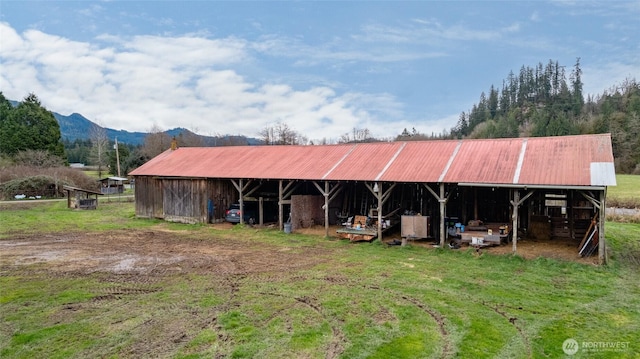 rear view of property with an outbuilding, a mountain view, and metal roof