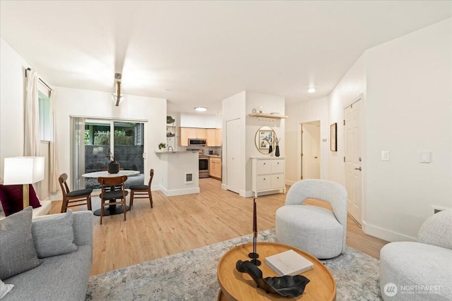 living area with light wood-style flooring, recessed lighting, and baseboards