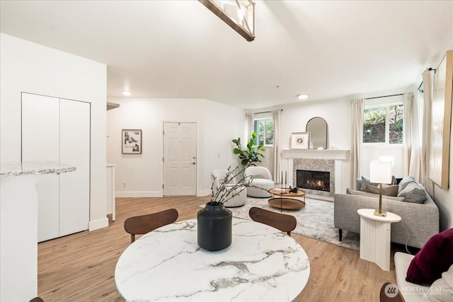 living area with a healthy amount of sunlight, a fireplace, and light wood-style floors