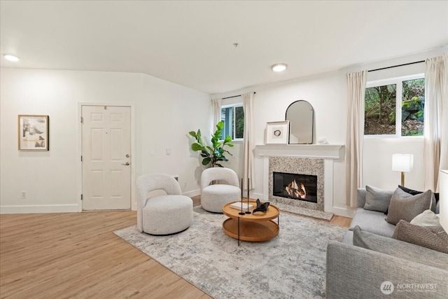 living room with recessed lighting, baseboards, wood finished floors, and a high end fireplace