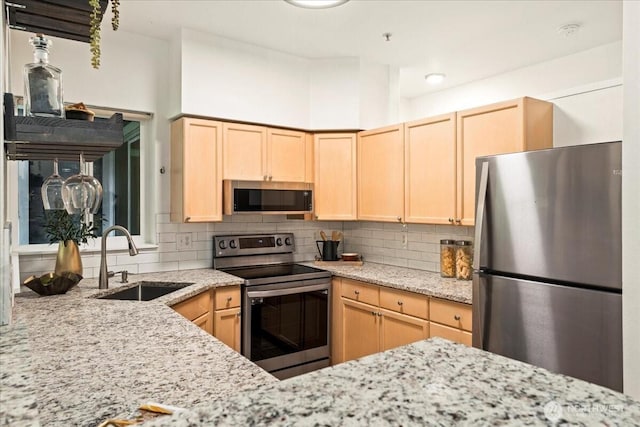 kitchen with decorative backsplash, light brown cabinets, stainless steel appliances, and a sink