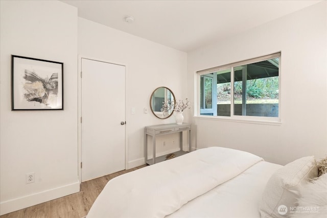 bedroom featuring baseboards and wood finished floors