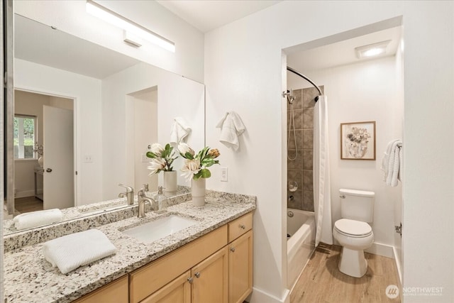 full bath with vanity, wood finished floors, baseboards, shower / washtub combination, and toilet