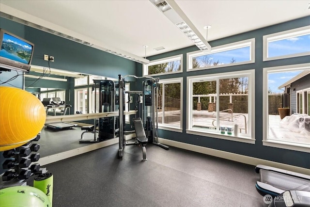 workout area featuring plenty of natural light, visible vents, and baseboards