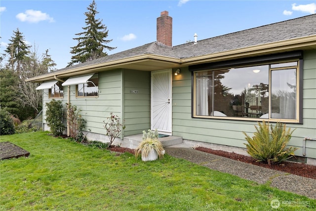 view of front of property featuring a chimney and a front lawn