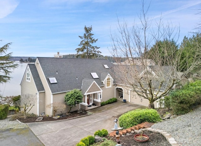 exterior space with concrete driveway, a garage, and a shingled roof